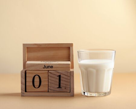  Glass cup with milk on a brown background with the inscription Milk Day. June 1st milk concept....