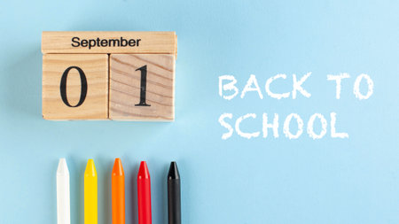 Banner with a wooden September 1 calendar, colored pens and back to school text on a blue background. Copy space Art concept of the beginning of the school year.の写真素材
