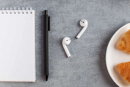 White Notepad, wireless headphones. The concept of online training, work from home, home office....