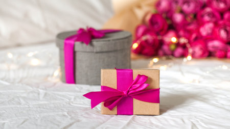 Gift boxes with pink ribbon on the bed. Concept of Valentine's day, March 8, birthday gift and other...