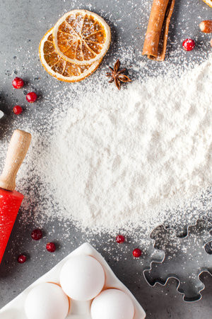 Spilled flour on a gray background surrounded by rolling pin, spices. Christmas background. Copy space. High quality photoの写真素材