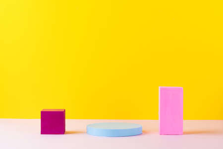 Empty colored bright podiums of abstract geometric shapes for product presentations. Copy space.