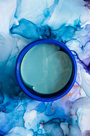 Anti-aging patches in blue packaging on a blue background. Korean cosmetics for skin care. Copy space.の写真素材