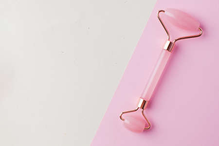Face roller jade of pink color. Face care at home, alternative medicine. Copy space.の写真素材