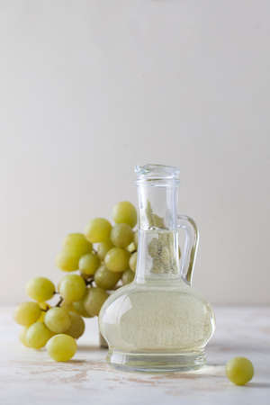 Organic vegetable oil from grape seeds in a glass bottle with green grapes.の写真素材