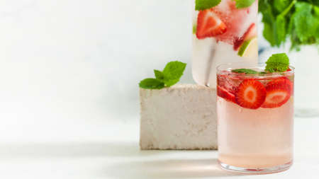 A refreshing summer drink with strawberries, lemon and mint in a glass on a light background. Strawberry lemonadeの写真素材