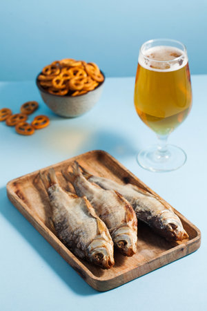 Dried salted fish on a wooden tray. A delicious snack for beer.