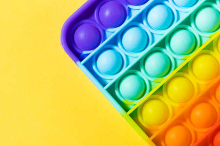 Pop it toy silicone on a yellow background. Anti-stress toy, a trend in childrens toys. Copy space.の写真素材