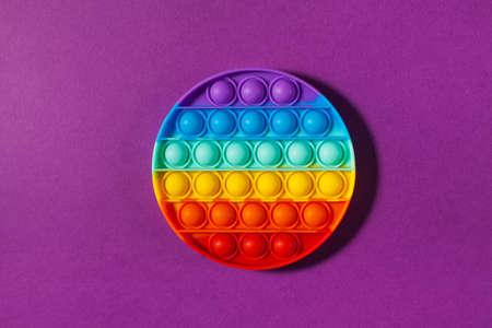 Pop it toy silicone on a purple background. Anti-stress toy, a trend in childrens toys. Copy space.