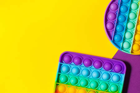 Pop it toy silicone on a yellow background. Anti-stress toy, a trend in childrens toys. Copy space.の写真素材