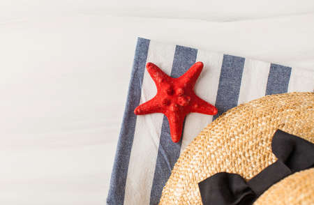A straw hat and a starfish on a light background. Summer background. Copy space.の写真素材