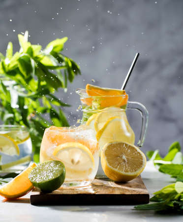 Refreshing lemonade with lemon and mint in a jug and glass with splashes. Summer drinks. Copy space.の写真素材