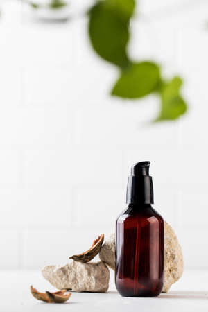 Organic cosmetic product in a brown dispenser surrounded by natural materials. An environmentally friendly product.の写真素材