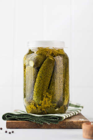 Pickled cucumbers in jars on a white background. Canning vegetables. Copy space.の写真素材