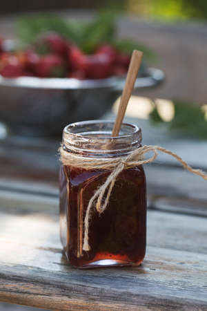 Strawberry jam in a jar on a wooden board. Fermented berries.の写真素材