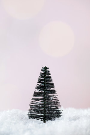 Christmas tree in the snow on a pink background. Minimalism. The concept of the New Year and Christmas. Copy space.の写真素材