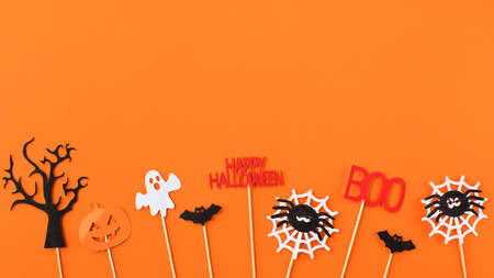 Childish Halloween flat lay with cute small holiday symbols on bright orangeの写真素材