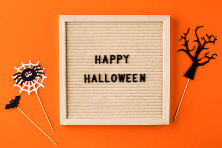 Greeting card with words Happy Halloween and ornate on orange colorの写真素材