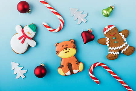 Composition of Christmas tree baubles gingerbread and candy canes on blue bannerの写真素材