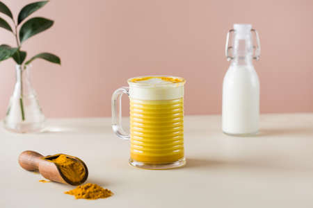 Latte turmeric on a pink background. Moon milk for better sleep. Copy space.の写真素材
