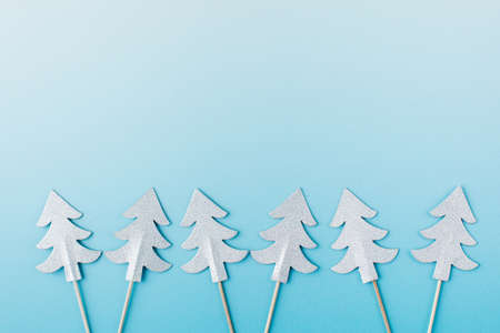 Group of cute paper Christmas trees on a light blue banner template. Copy space