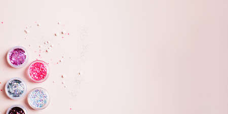 Banner. Shiny glitter powder for festive manicure Christmas party on pink background. Copy spaceの写真素材