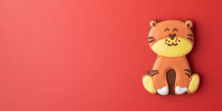 Gingerbread Christmas tiger on a red background. Year of the tiger according to the Chinese zodiac calendar. Copy spaceの写真素材