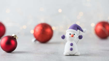 Funny snowman on the background of Christmas red balls and bokeh. Christmas and New Year concept. Copy space. Bannerの写真素材