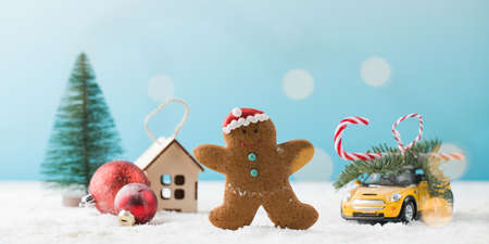 Gingerbread man toy car and traditional Christmas ornament on artificial snowの写真素材