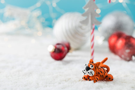 Toy tiger oriental symbol of next year on fake snow against Christmas decorの写真素材