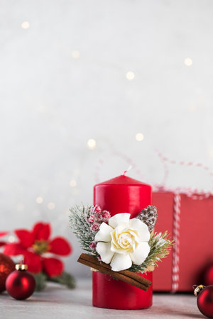 Christmas red candle surrounded by Christmas balls on a light background. Copy space.の写真素材