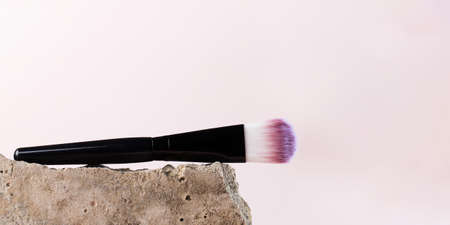 Cosmetic brush for blush, softening near a grey stone. Copy space.の写真素材