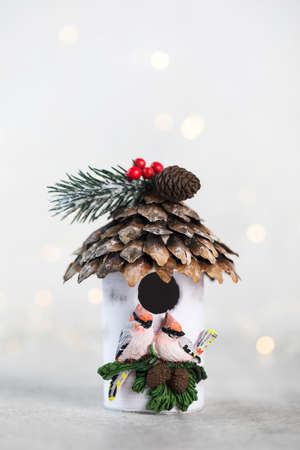 Christmas composition with a birdhouse and christmas lights. Copy space.の写真素材