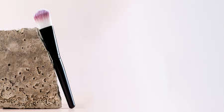Cosmetic brush for blush, softening near a grey stone. Copy space.の写真素材
