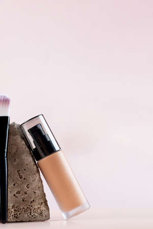 Cosmetic brush and foundation next to a grey stone. Copy space.の写真素材