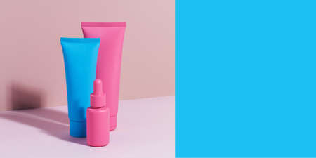 Different mockups of cosmetic bottles on a pink background. Banner. Copy space