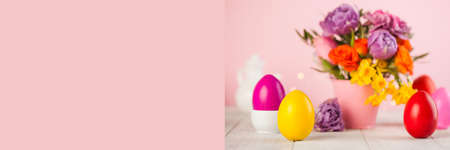 Easter card. Colorful Easter eggs on the background of a bouquet of flowers. Copy space.