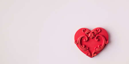 Red heart made of polymer clay on a pink background. Copy spaceの写真素材