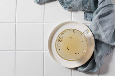 Healthy golden bone broth with spices in a mug on a saucer on a white background. Copy space. Top viewの写真素材