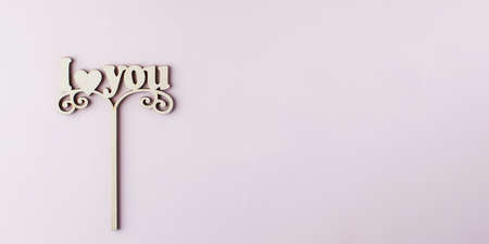 A wooden axe with the words I LOVE YOU on a pink background. Copy space.の写真素材