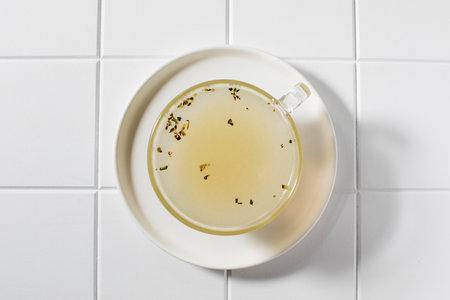 Healthy golden bone broth with spices in a mug on a saucer on a white background. The concept of keto diets. Top viewの写真素材
