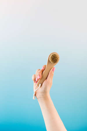 Exfoliating dry facial brush made of natural bristles in a womans hand. Peeling, detox for the skin of the face.の写真素材