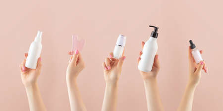 A horizontal banner with mockups of cosmetics in a womans hand. Skin care, the concept of a beauty salon.の写真素材