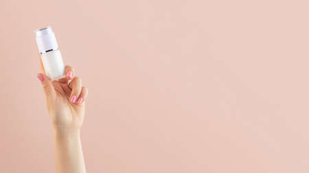 A mock-up of a jar of moisturizer in a womans hand on a pink background. Banner
