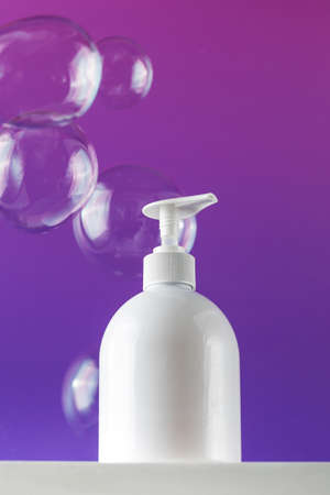 Mockup of a white dispenser with a cosmetic product on a pedestal on a purple background and flying...