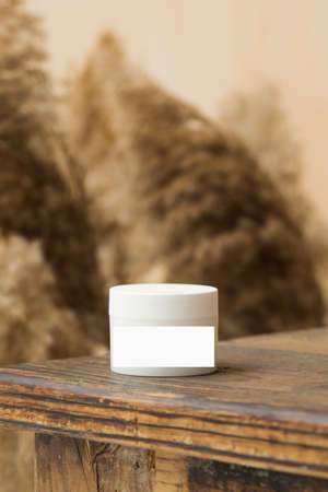 Mockup of a white jar of face and body skin cream on wooden tabletop. Friendly product.