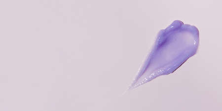A smear of purple cosmetics on a pink background. A sample for advertising. Copy spaceの写真素材