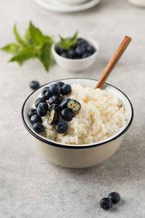 Rice milk porridge with blueberries in a bowl close-up. The concept of a healthy and tasty breakfast.の写真素材
