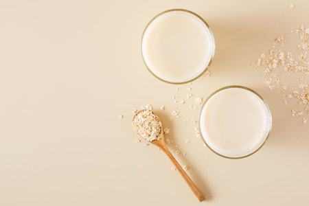Oat milk in a glass, flakes of baked cereals. Milk substitute, milk for vegetarians. Flatlay. Copy space.の写真素材