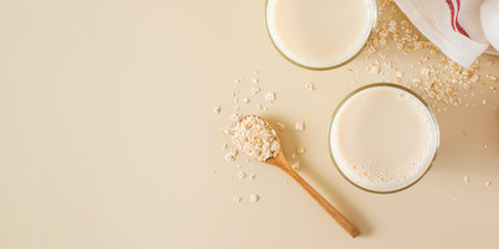 Oat milk in a glass, flakes of baked cereals. Milk substitute, milk for vegetarians. Flatlay. Copy space.の写真素材